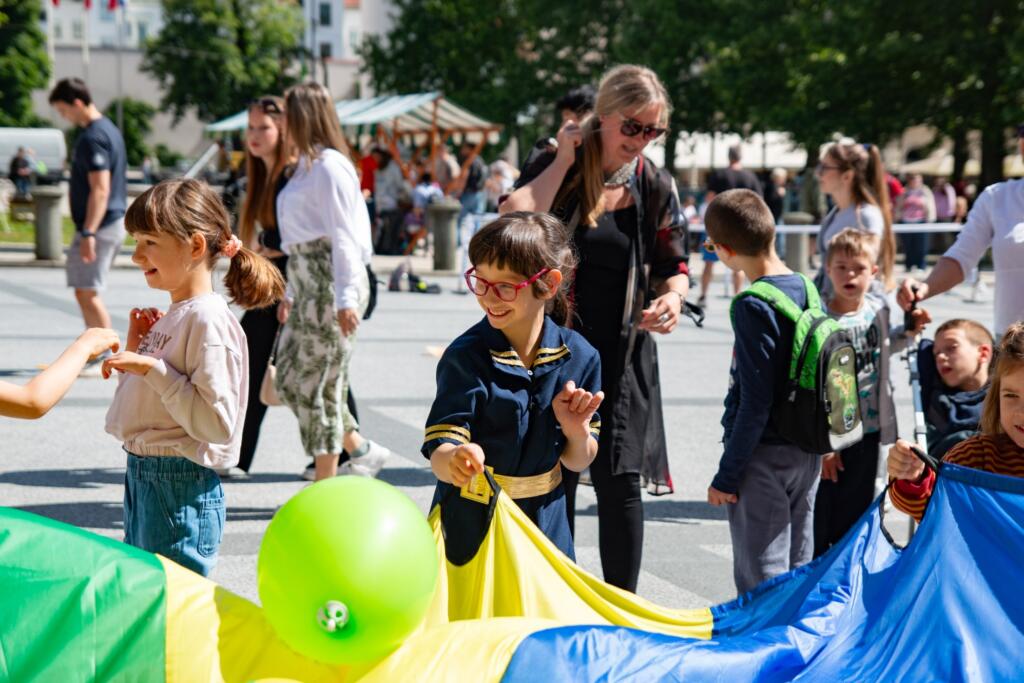 Ljubljana / Deklica med igro s padalom in balonom na festivalu »Igraj se z mano«. Foto: Maša Pelc