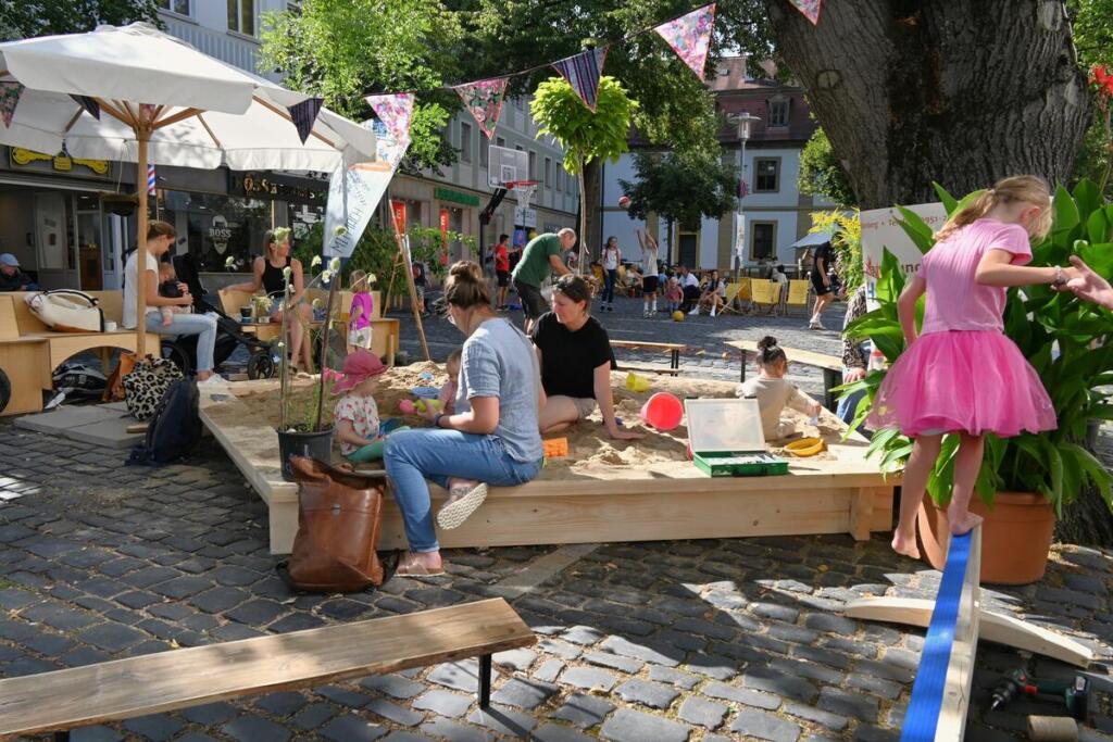V nemškem Bambergu je bil prostor v zgodovinskem mestnem središču, ki so ga pretežno zasedala parkirišča, s pomočjo kulturnih programov in sodelovanja lokalne skupnosti preoblikovan v živahen prostor srečevanja in druženja. Izkušnje so med drugim pokazale, da so peskovniki preprost, a učinkovit način za privabljanje otrok in oživljanje javnih površin. Foto: Sebastian Martin.